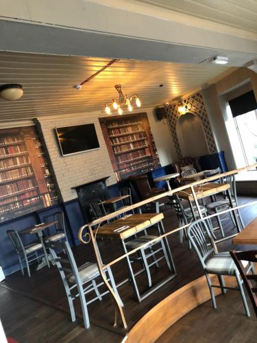 a restaurant with tables and chairs in a room at The Dorrington in Halstead