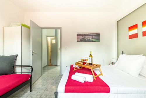 ein Schlafzimmer mit einem Bett und einem Tisch mit einer Flasche Wein in der Unterkunft Litsa's Suite in Iraklio