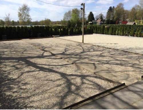 a shadow of a pole on a street at Rumah kita, bungalow met 2 slaapkamers in het mooie Drenthe in Erm