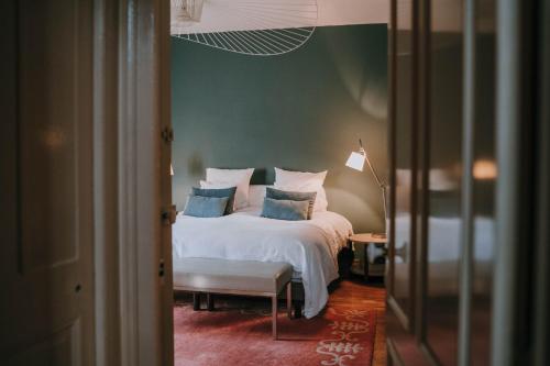 - une chambre avec un lit blanc et des oreillers bleus dans l'établissement Castel Jolly, à Rennes
