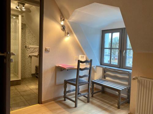 フィジャックにあるHôtel des Bainsのデスク、椅子、窓が備わる客室です。