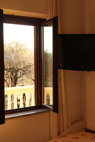 a bedroom with a window with a view of a balcony at Villa Malandrino Guest House in Agropoli