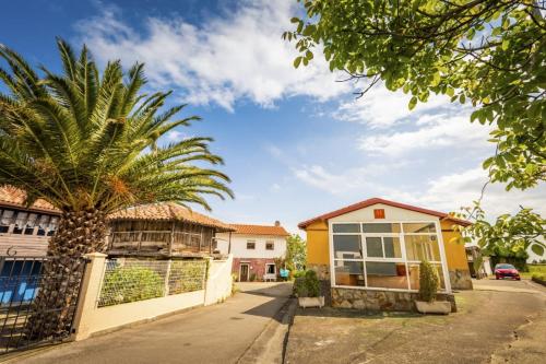 a palm tree in front of a house at Apartamentos Pumarin in Santa Marina