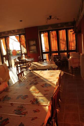 a dining room with tables and chairs and windows at Villa Malandrino Guest House in Agropoli