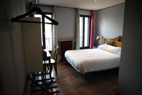 Un pat sau paturi într-o cameră la Arnaud Bernard Hôtel