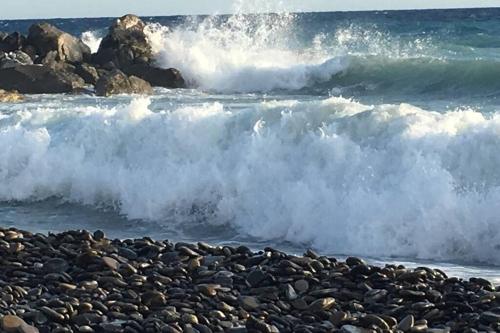 a group of waves crashing on a rocky beach at Home La Quiete. Two Bedrooms, 250m from the Beach in Ospedaletti