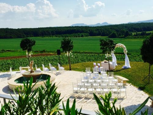 a wedding reception in a field with white chairs at Liszkay Borkúria in Monoszló