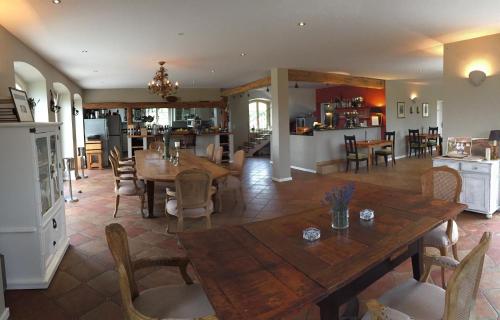 a dining room and kitchen with a wooden table and chairs at Liszkay Borkúria in Monoszló