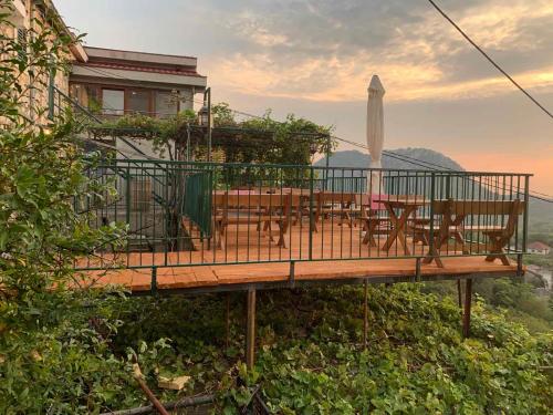 a wooden deck with a table and an umbrella at Apartments "Old house Pajovic" in Virpazar
