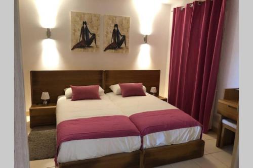 una camera da letto con un grande letto con tende rosse di 4 Sterne Appartment Sal Kap Verden a Prainha