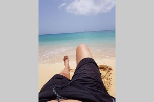a person laying on the sand at the beach at 4 Sterne Appartment Sal Kap Verden in Prainha