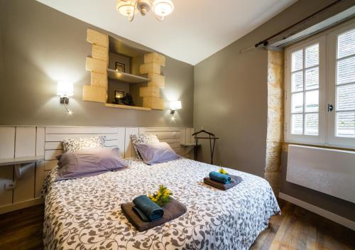een slaapkamer met een bed met 2 kussens erop bij La Ritournelle in Sarlat-la-Canéda