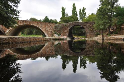 an old bridge with two arches over a river at Casa Rural Las Jañonas CC-CR-00219 in Gata