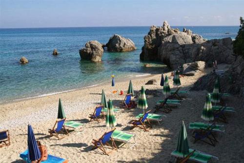 a group of chairs and umbrellas on a beach at Case Vacanze Giardino in Parghelia