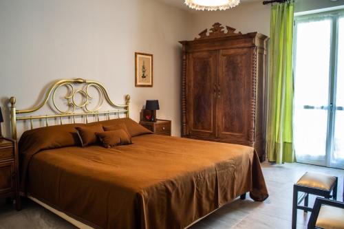 Un dormitorio con una cama grande y un gran armario de madera. en Appartamenti Rocca - CAV La Casa di Rosa, en Monforte dʼAlba