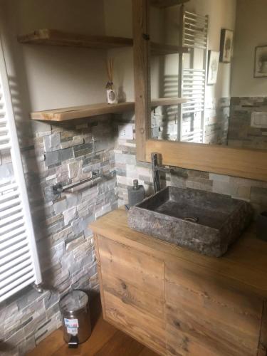 uma cozinha com um lavatório e uma parede de tijolos em Monolocale di charme a due passi da courmayeur em Pré-Saint-Didier