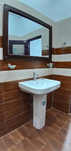 a bathroom with a sink and a mirror at Airport Pearl Garden Transit Hotel in Arambe