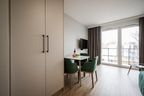 a room with a table and chairs and a window at Marina Apartments ZOO in Wrocław