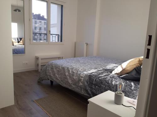 ein kleines Schlafzimmer mit einem Bett und einem Spiegel in der Unterkunft Appartement haussmannien au bord du lac panorama in Clamart