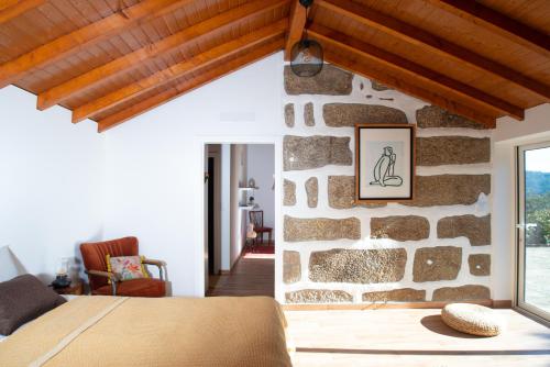 - une chambre dotée d'un mur en pierre et d'un lit dans l'établissement Quinta do Mirante, à Castelo de Paiva