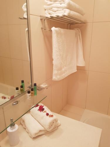 bagno con lavandino, specchio e asciugamani di 4 Sterne Appartment Sal Kap Verden a Prainha