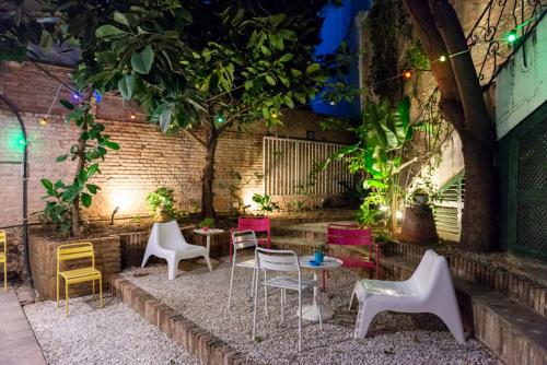 un patio con mesas, sillas y un árbol en ABCyou Bed&Breakfast en Valencia