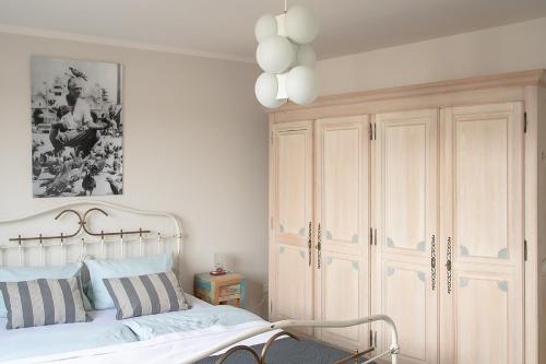 a bedroom with a white bed and a white cabinet at Seesterne Residenz in Konstanz