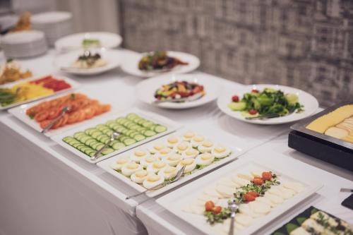 a table filled with different types of food on plates at Marina Apartments ZOO in Wrocław