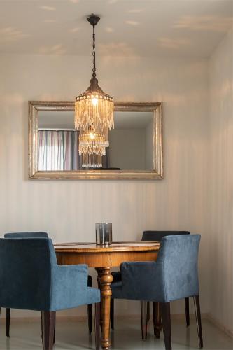 a dining room table with blue chairs and a chandelier at Seesterne Residenz in Konstanz