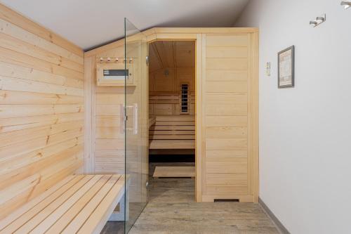 a sauna with wooden walls and a glass door at A50 Cape Town Penthouse - Silver Mountain in Poiana Brasov