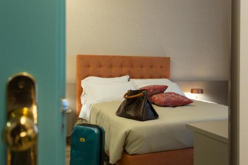 a bedroom with a bed with a bag on it at Casaalbergo La Rocca in Noale