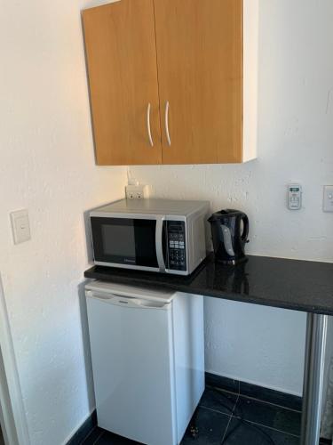 a microwave sitting on top of a counter in a kitchen at Lemon Tree Guest Cottage in Featherbrooke Estate in Krugersdorp
