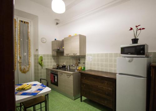 a kitchen with a white refrigerator and a table at Dream Destination Rome in Rome