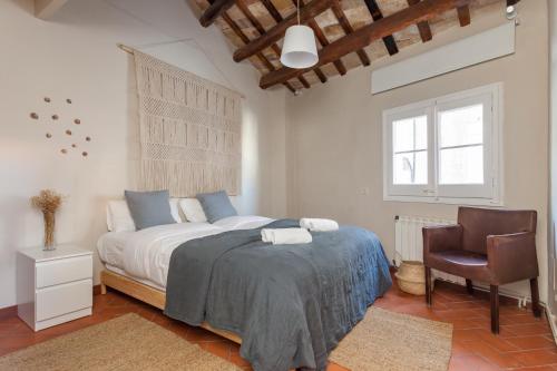 a bedroom with a bed and a chair in it at La Casita - centro histórico y playa in Sitges