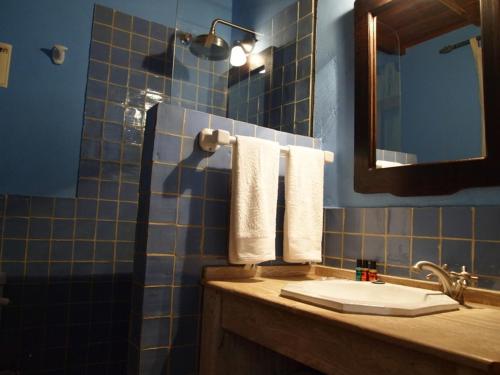 ein Badezimmer mit einem Waschbecken, einem Spiegel und Handtüchern in der Unterkunft Casa Rural Las Jañonas in Gata