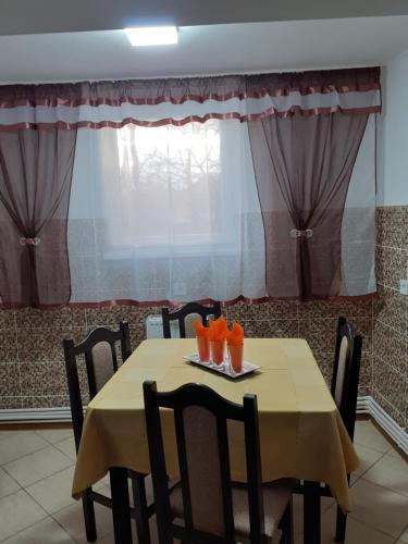 a table with chairs and orange glasses on it at Casa Leucian in Deva