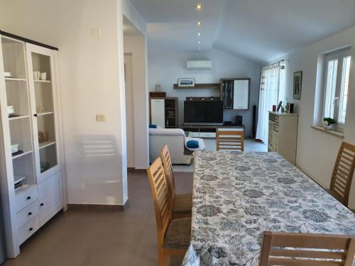 een woonkamer met een tafel en stoelen en een keuken bij Apartman Baric in Sevid