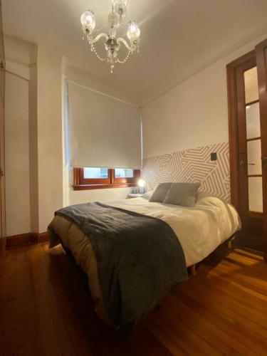 una camera da letto con un grande letto e un lampadario a braccio di Buenos Aires Downtown Experiencie #BAExp09 a Buenos Aires