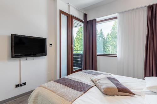 a bedroom with a bed and a television on a wall at B09 Mauritius - Silver Mountain in Poiana Brasov