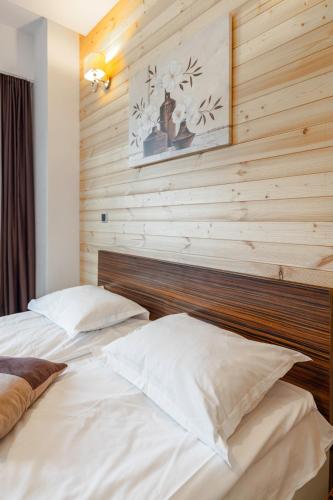 two beds in a bedroom with a wooden wall at B09 Mauritius - Silver Mountain in Poiana Brasov