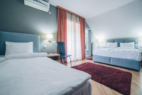 a hotel room with two beds and a window at Garni Hotel Radović in Kragujevac