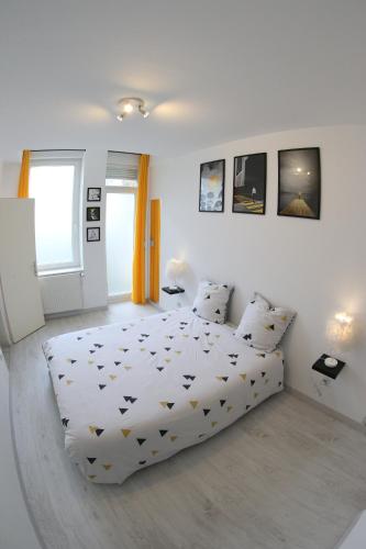 a white bedroom with a bed and two pillows at Sympathique logement en centre ville in Verdun