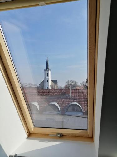 a window with a view of a church at Szépségpatika Apartman in Sárospatak