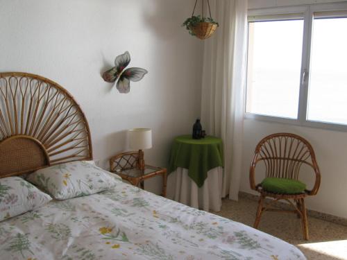 a bedroom with a bed and a table and a window at 1ª LINEA DE MAR CON VISTA FANTÁSTICA in L'Ampolla