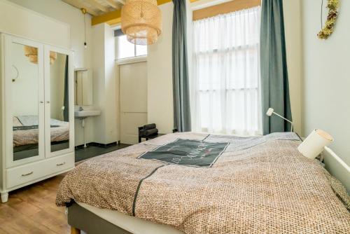 - une chambre avec un lit et une grande fenêtre dans l'établissement Pakhuis de Venkel, à Zierikzee