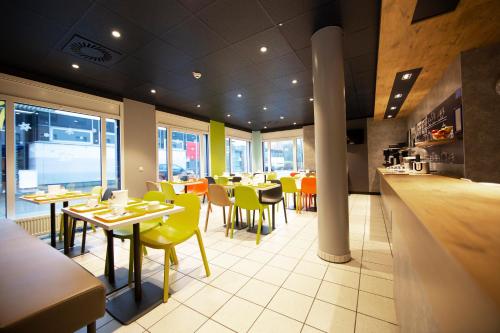 un restaurante con mesas, sillas y una barra en ibis budget Flensburg Handewitt en Handewitt