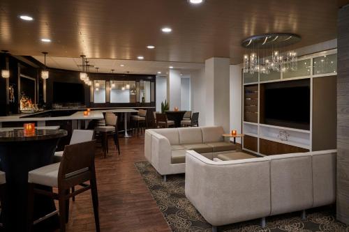 a living room with a couch and a bar at Holiday Inn Alexandria at Carlyle by IHG in Alexandria