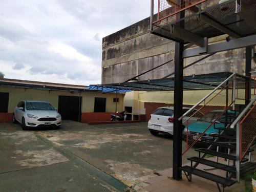 due auto parcheggiate in un parcheggio accanto a un edificio di Departamento centrico en Posadas, garage opcional D1 a Posadas