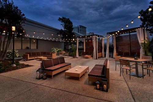 a patio with furniture and lights on a building at Holiday Inn Alexandria at Carlyle by IHG in Alexandria