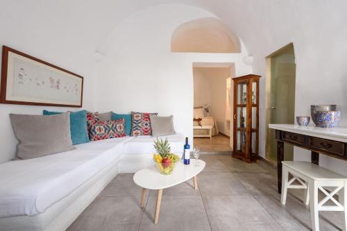 a living room with a white couch and a table at Arvanitis Cave Village in Akrotiri